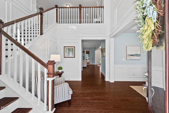 entrance foyer featuring stairway, wood finished floors, and a decorative wall