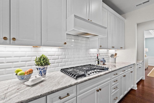 kitchen featuring visible vents, stainless steel gas cooktop, dark wood-style floors, custom exhaust hood, and white cabinetry