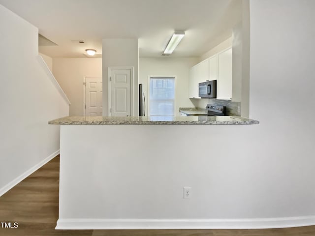 2356 Bay Harbor Dr, Raleigh, NC 27604 - kitchen featuring white cabinetry, a peninsula, light stone counters, and stainless steel appliances