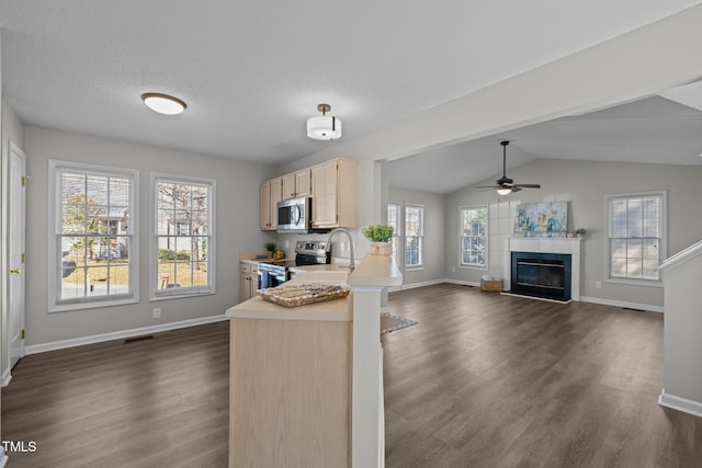 kitchen featuring light brown cabinets, visible vents, light countertops, appliances with stainless steel finishes, and open floor plan