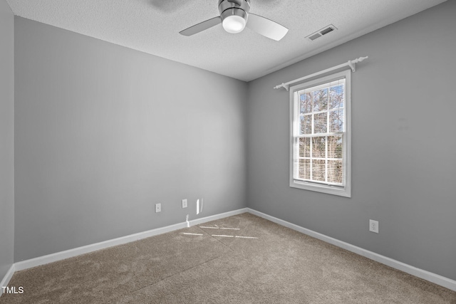 carpeted empty room featuring visible vents, baseboards, a textured ceiling, and a ceiling fan