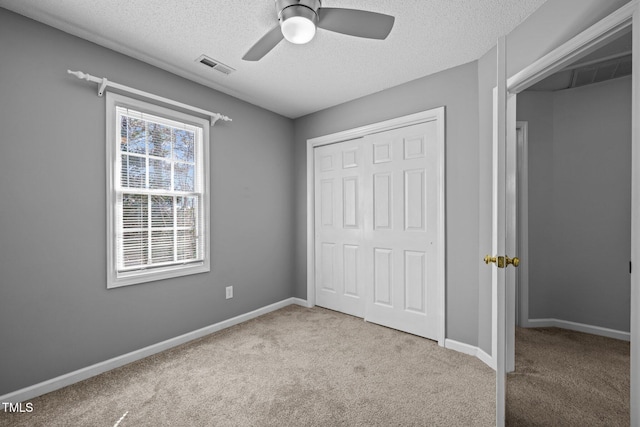 unfurnished bedroom featuring carpet, visible vents, a closet, and baseboards