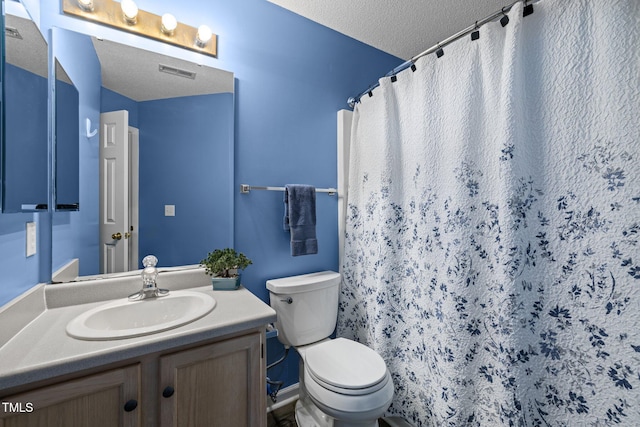 bathroom featuring visible vents, toilet, vanity, a shower with curtain, and a textured ceiling