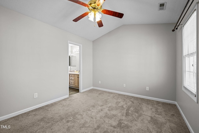 unfurnished bedroom featuring vaulted ceiling, carpet, baseboards, and connected bathroom