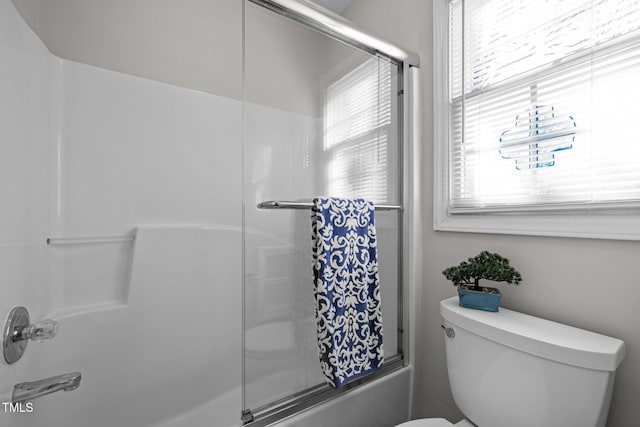 full bathroom with plenty of natural light, shower / bath combination with glass door, and toilet