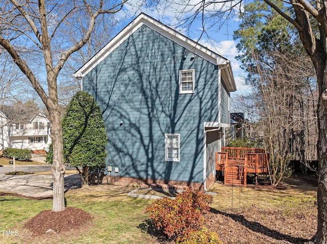 view of side of property with a wooden deck and a lawn