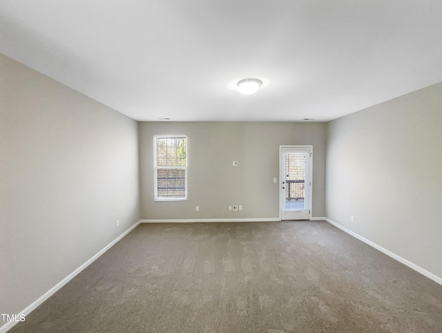 carpeted empty room with baseboards