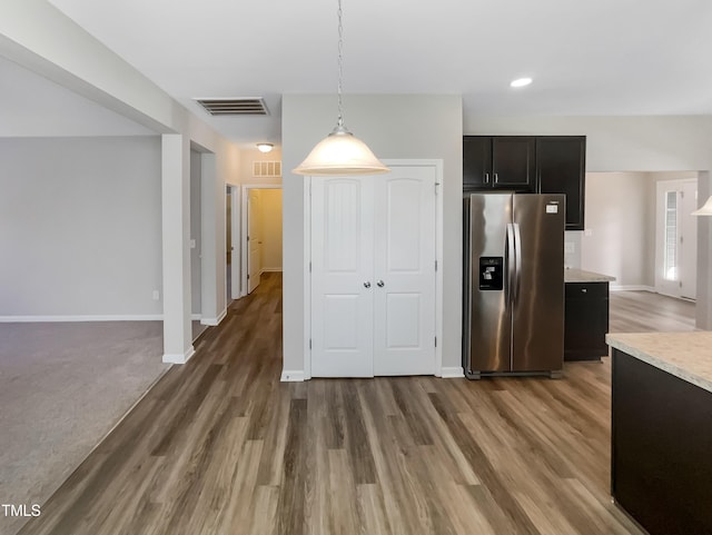 kitchen with wood finished floors, stainless steel fridge with ice dispenser, and visible vents