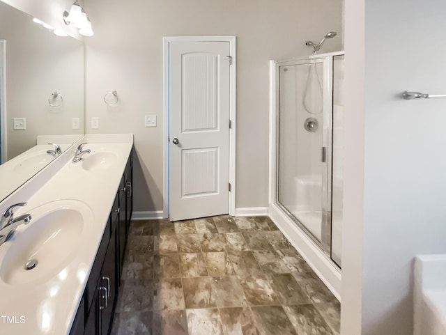 full bathroom featuring double vanity, a shower stall, and a sink