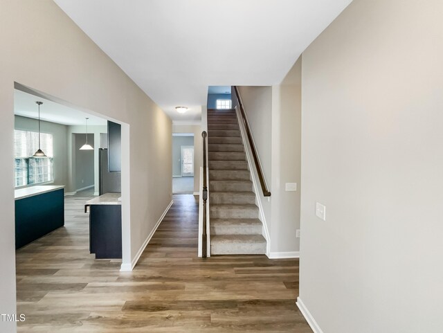 staircase featuring baseboards and wood finished floors