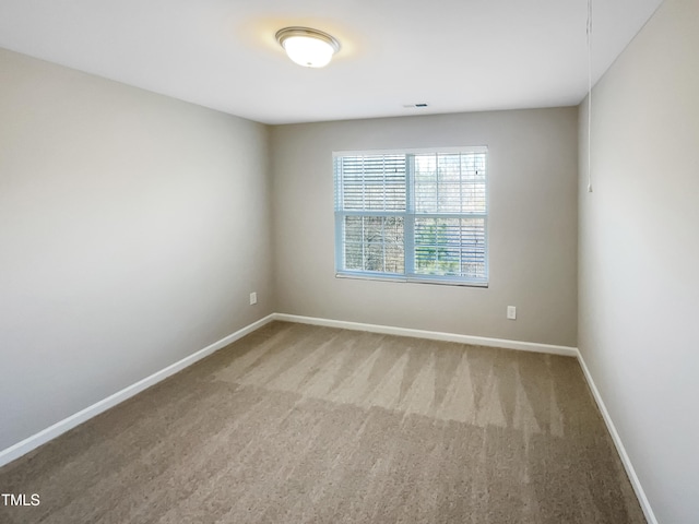 carpeted empty room featuring visible vents and baseboards