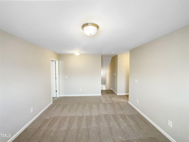 spare room featuring carpet flooring and baseboards