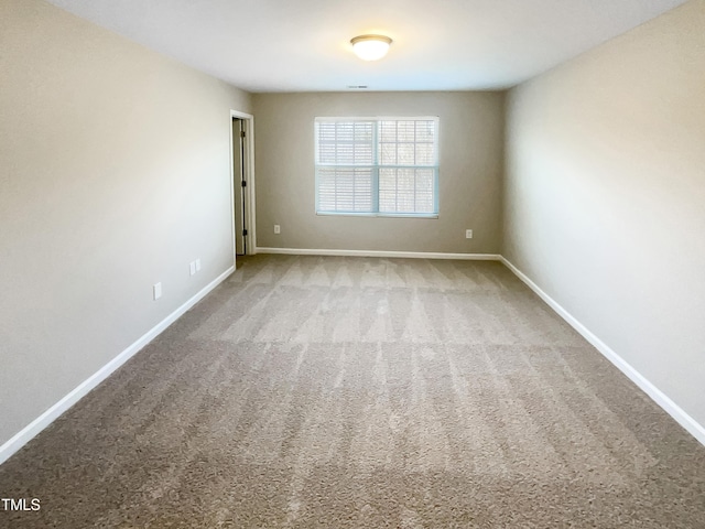 carpeted spare room with baseboards