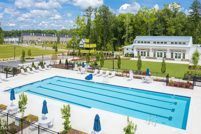 pool with a yard, a patio area, and fence