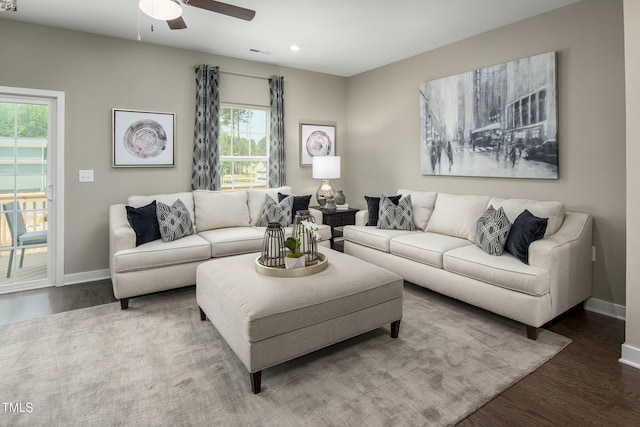 living room with wood finished floors, visible vents, and baseboards