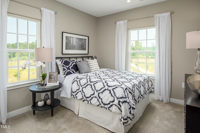 bedroom featuring carpet flooring, multiple windows, and baseboards