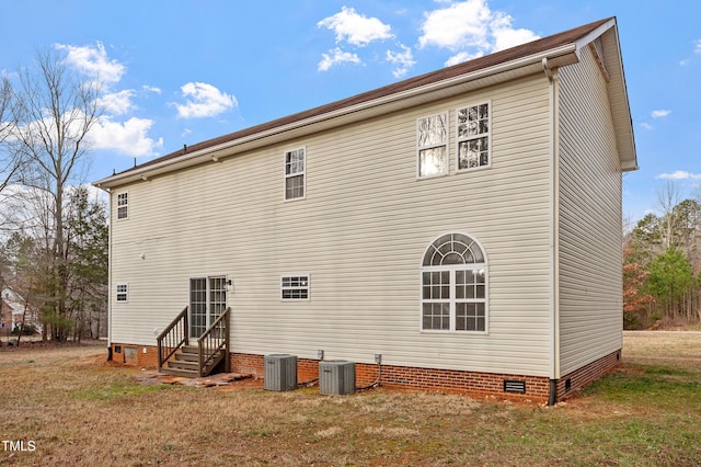 back of house with crawl space, central air condition unit, a lawn, and entry steps