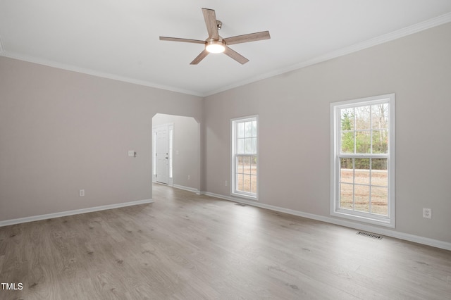 spare room featuring crown molding, light wood-type flooring, visible vents, and ceiling fan