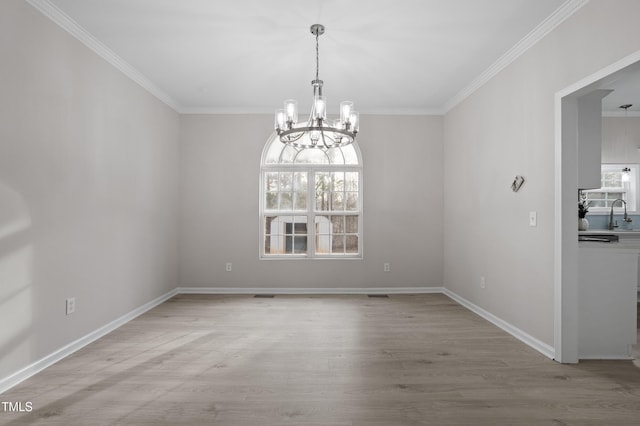 spare room with baseboards, light wood-style flooring, and ornamental molding