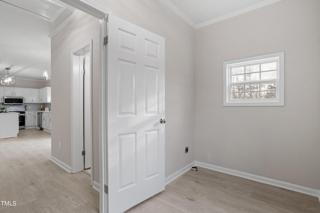 interior space with light wood-style flooring, crown molding, and baseboards