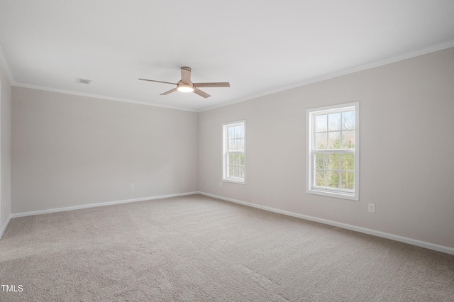 unfurnished room featuring visible vents, crown molding, baseboards, carpet, and a ceiling fan