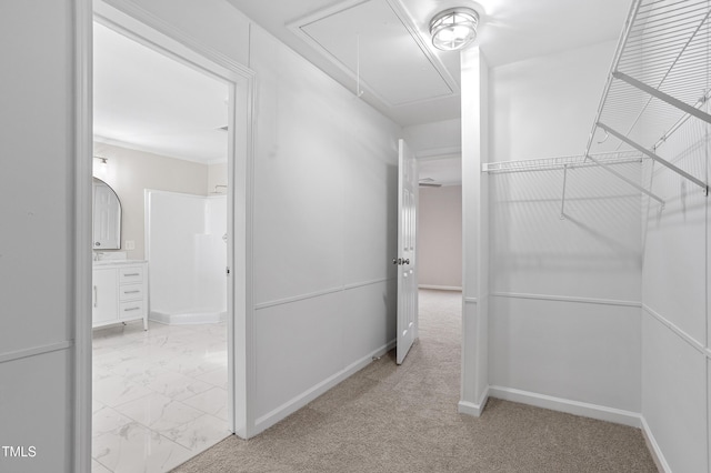 walk in closet featuring marble finish floor and attic access