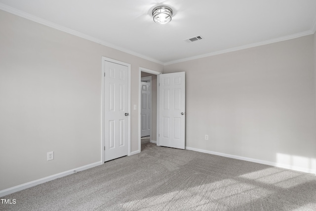 carpeted empty room featuring visible vents, baseboards, and ornamental molding