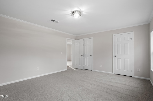 unfurnished bedroom featuring visible vents, baseboards, carpet flooring, and crown molding