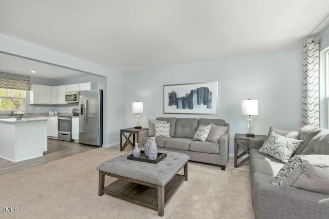 living room featuring light carpet and baseboards