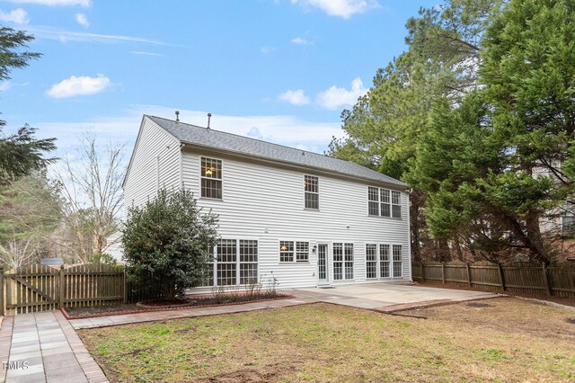 rear view of house with a patio area, fence private yard, and a lawn