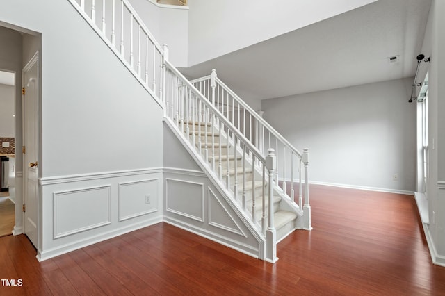 staircase with a decorative wall and wood finished floors