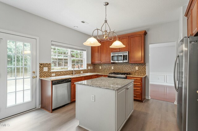 kitchen featuring visible vents, backsplash, light wood-style floors, stainless steel appliances, and a sink