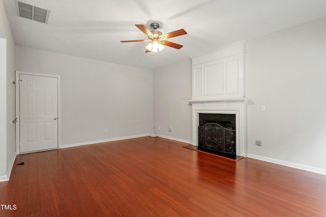 unfurnished living room with visible vents, a fireplace, ceiling fan, and wood finished floors