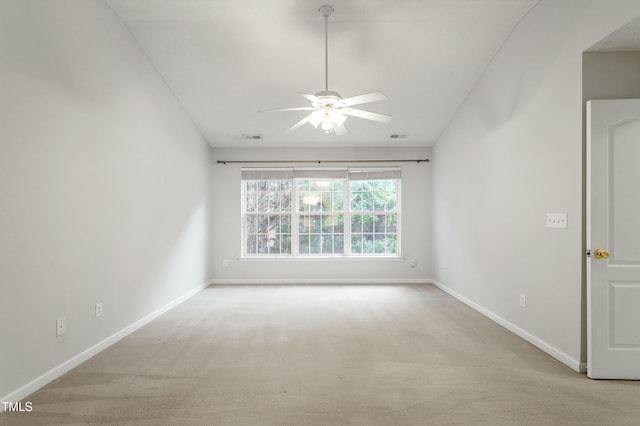 carpeted spare room featuring visible vents, baseboards, and ceiling fan