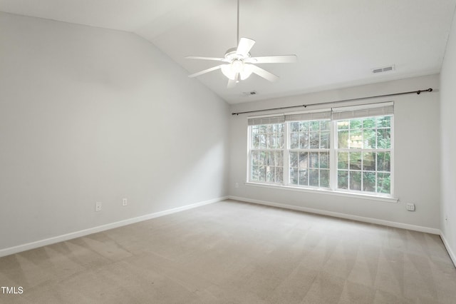 carpeted empty room with visible vents, a ceiling fan, baseboards, and vaulted ceiling