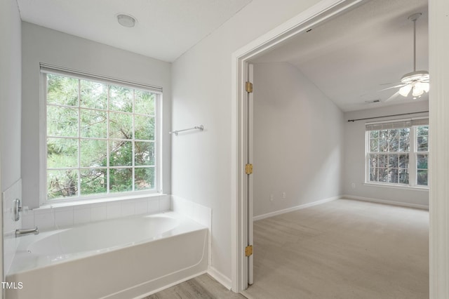 full bath with visible vents, a healthy amount of sunlight, a garden tub, and wood finished floors