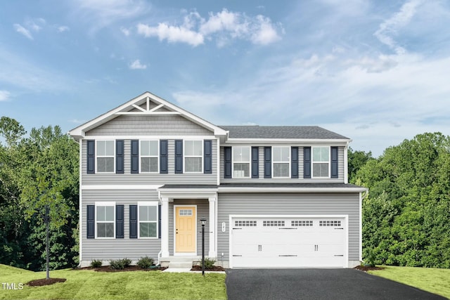 view of front of property featuring a front lawn, a garage, and driveway