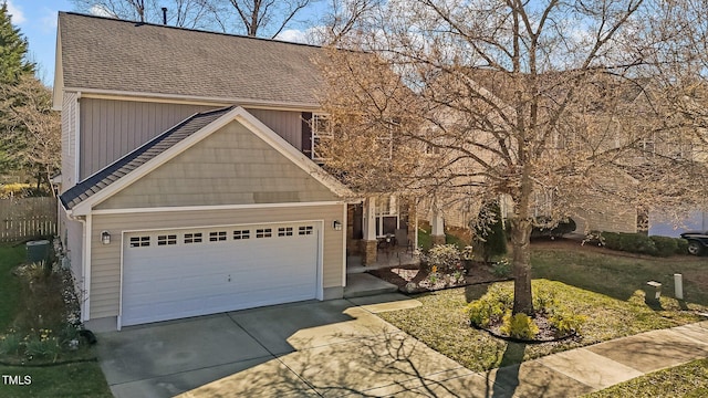 view of front facade with concrete driveway, an attached garage, and roof with shingles