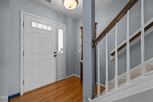 entrance foyer with light wood finished floors, stairway, and baseboards