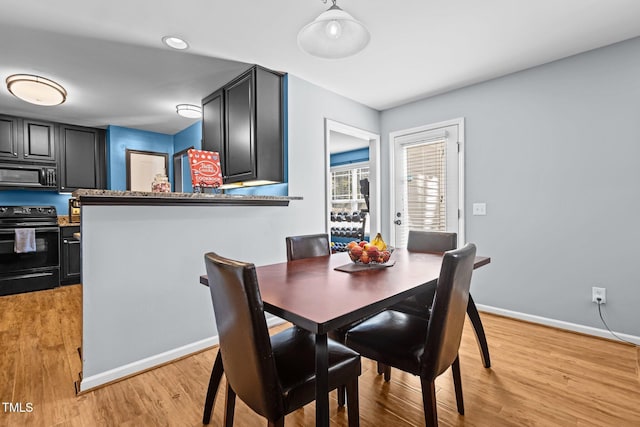 dining room with baseboards and light wood-style floors