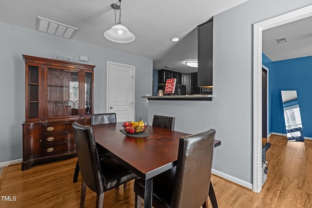 dining space with baseboards, visible vents, and light wood-type flooring