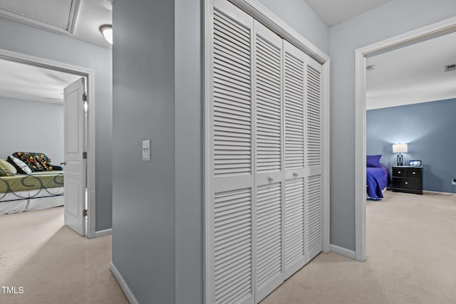 hallway featuring visible vents, baseboards, and carpet flooring