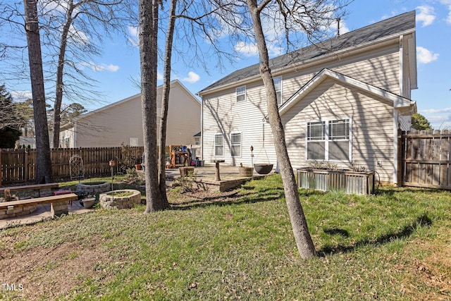 back of property featuring a patio area, a garden, a yard, and fence