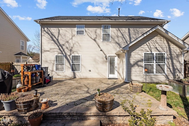 rear view of property featuring a patio and fence