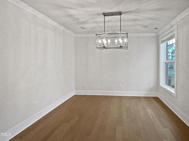 unfurnished dining area with dark wood finished floors, crown molding, and baseboards