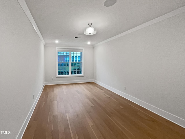 empty room with visible vents, baseboards, ornamental molding, dark wood-type flooring, and a textured ceiling