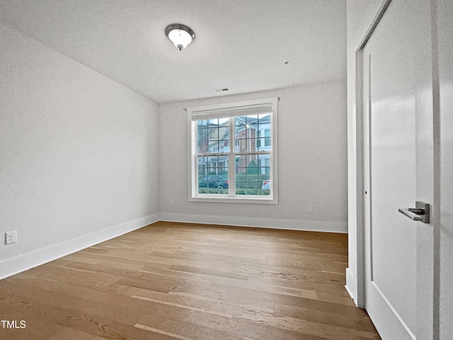 spare room with wood finished floors and baseboards