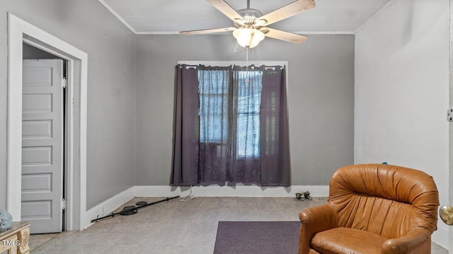 living area with baseboards, crown molding, and a ceiling fan