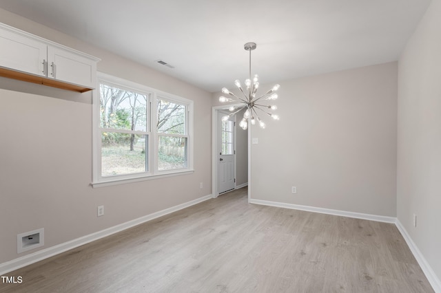 unfurnished dining area featuring light wood-style flooring, baseboards, visible vents, and a chandelier