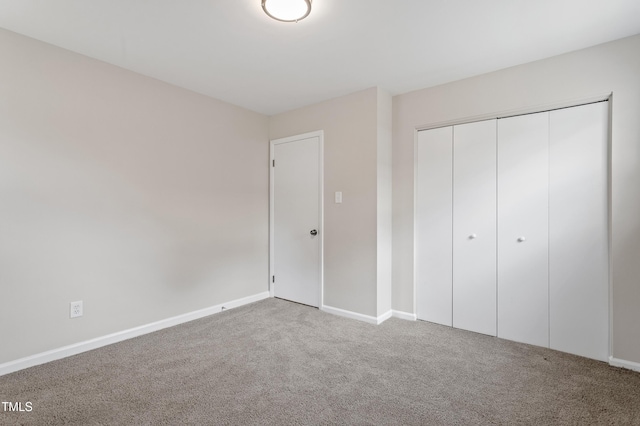 unfurnished bedroom featuring carpet, a closet, and baseboards